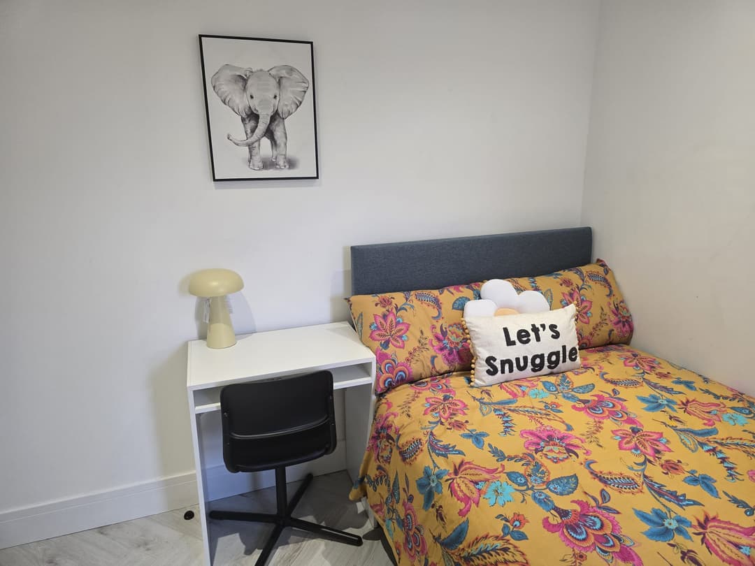 YCN Colney Home bedroom with yellow floral duvet and study desk — warm, homely environment